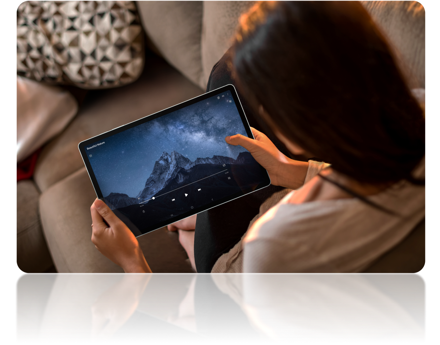 Image of a person holding the galaxy tablet and streaming a video displaying a mountain and a sky with stars.