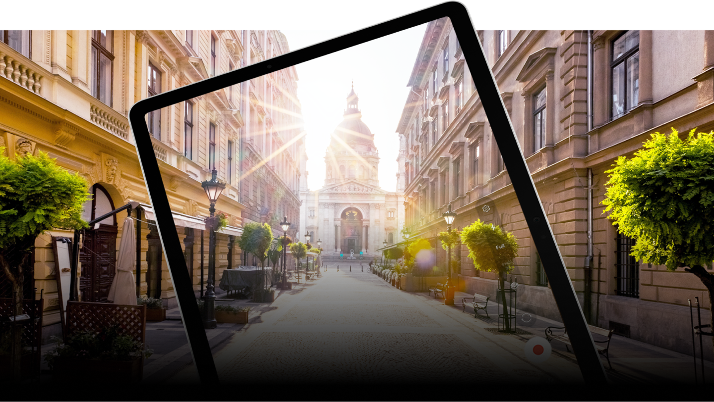 Display of tablet's frame and a photo of sunny road in a city and in the end of the road is a cathedral.