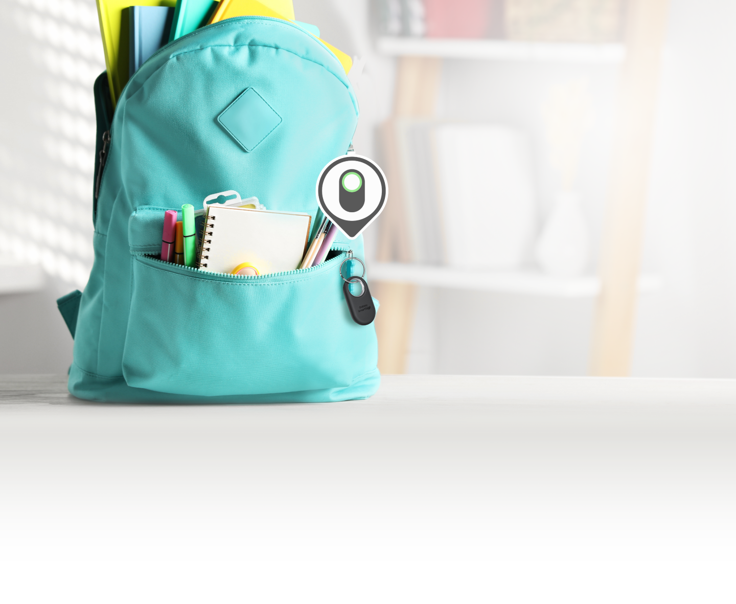 blue school rucksack with notepad, with a smart tag attached to the zip