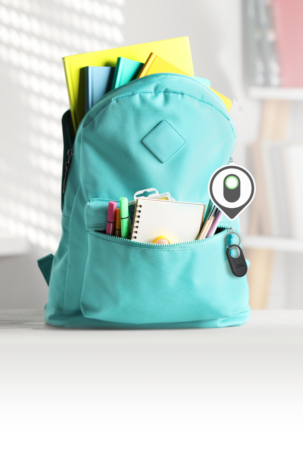blue school rucksack with notepad, with a smart tag attached to the zip